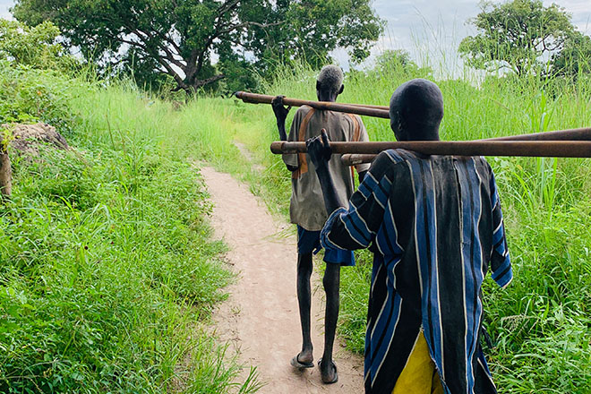 Waralel men carrying pipes for hours to build a village bore for safe water. Waralel men carrying pipes for hours to build a village bore for safe water.