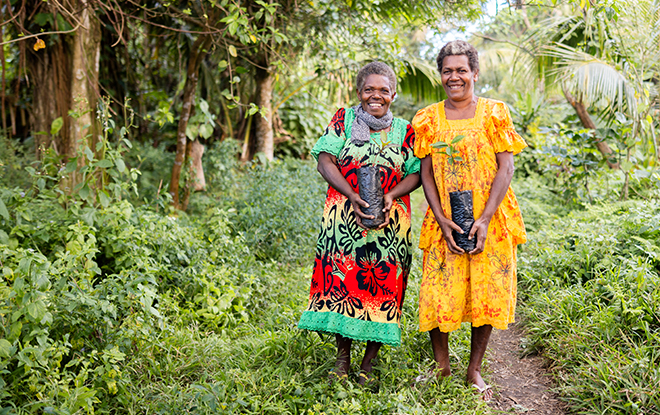 Work committee secretary (left) and project participant (right) holding seedlings from the Site 1 nursery in Middlebush